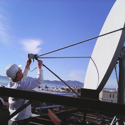 Technicien installant une parabole professionnelle sur toit